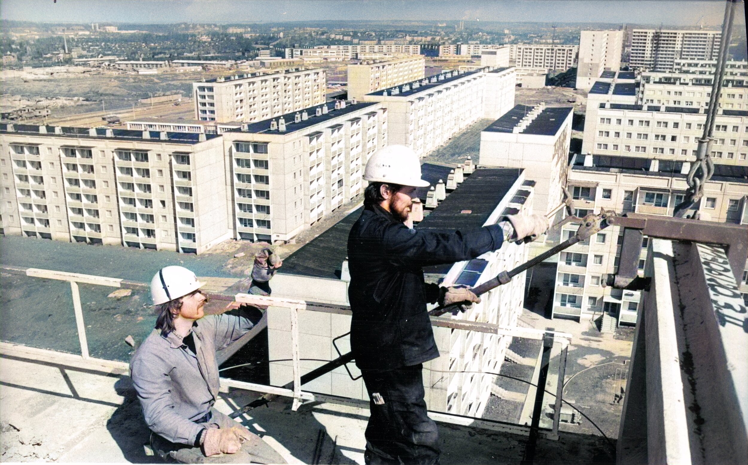 Bauarbeiter während der Arbeit auf dem Dach eines Wohnblocks auf der Allende-Straße 156-160. Das Bild entstand im Jahr 1978.
